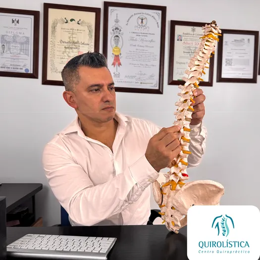 Hombre sosteniendo columna vertebral en sus manos
